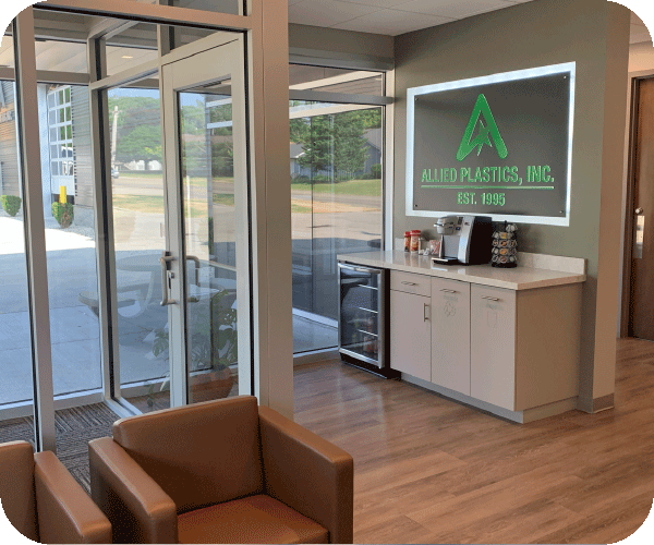 Company's main lobby with a nice seating area, a coffee counter with an Allied Plastics sign on the back wall.